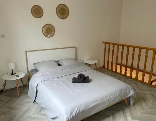 une chambre avec un lit avec un chapeau dessus dans l'établissement ღ Cormier • Situé au cœur de Douai & Spacieux, à Douai