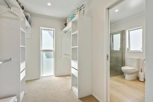 a bathroom with a toilet and a walk in closet at Estuary Bliss Getaway in Mangawhai