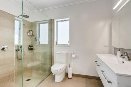 a bathroom with a toilet and a sink and a shower at Estuary Bliss Getaway in Mangawhai