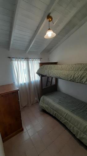 ein Zimmer mit zwei Etagenbetten und einem Tisch in der Unterkunft Casa Azul a 5 cuadras del centro y a 8 del mar in Villa Gesell