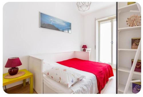 1 dormitorio blanco con 1 cama con manta roja en Casa Rizzoli - bilocale vicinissimo M2, en Milán