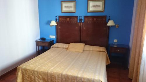 a small bedroom with a bed and blue walls at Hotel Iberia Plaza América in Cáceres