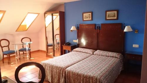 1 dormitorio con 1 cama y 1 mesa con sillas en Hotel Iberia Plaza América en Cáceres