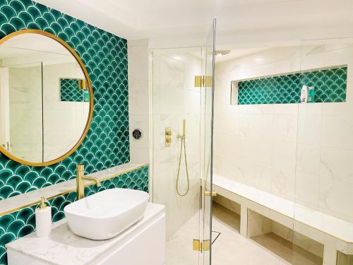 a bathroom with a sink and a shower with a mirror at Hidden Retreat with Steam room, KING bed near tube in London