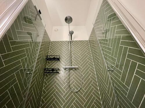 a bathroom with a green and white tiled wall at Berlin Loft nähe Olympiastadion in Berlin