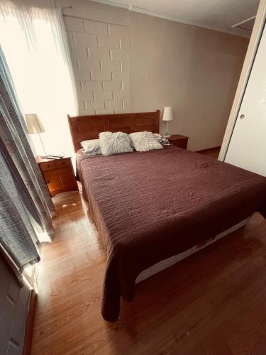 um quarto com uma cama grande com duas almofadas em Casa Piacenza, Cerca De Mall y Faro La Serena em La Serena