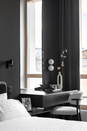 a bedroom with a bed and a desk with two chairs at FORUM apart in Lviv