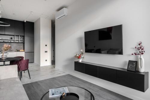 a living room with a tv on a white wall at FORUM apart in Lviv