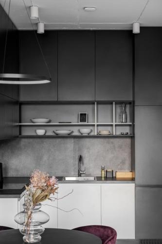 a kitchen with black and white cabinets and a table at FORUM apart in Lviv