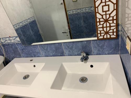 a bathroom with two white sinks and a mirror at Appartement meublé sans vis à vis proche de toutes commodités 5 min à Marjane chaikh Zaid et centre ville in Khouribga