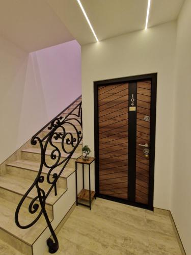a house with a wooden door and a staircase at Olimp Apartmani Bijeljina in Bijeljina