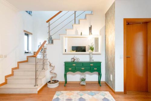 a room with a green desk and stairs at Quarto Brejos-Azeitão in Aldeia Rica