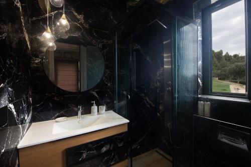 a bathroom with a sink and a mirror at Infinity blue villa in Nikiti