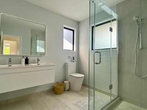 uma casa de banho com um WC e uma cabina de duche em vidro. em Coatesville Country Retreat em Auckland