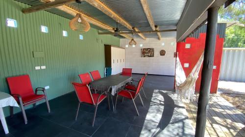 comedor con mesa y sillas rojas en Ampakiti Home, en Punta del Este