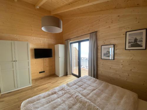 a bedroom with a bed and a large window at Wohlfühlchalet Hermagor-Nassfeld-Weissensee in Hermagor