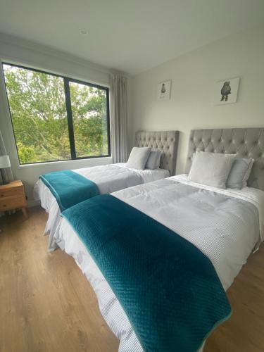 dos camas sentadas una al lado de la otra en un dormitorio en Coatesville Country Retreat, en Auckland