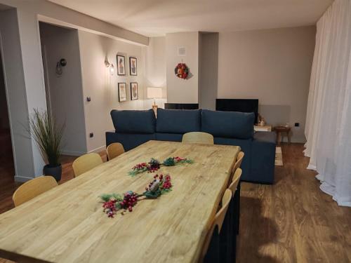 a living room with a table and a blue couch at Apartamentos Playa de Camariñas in Camariñas
