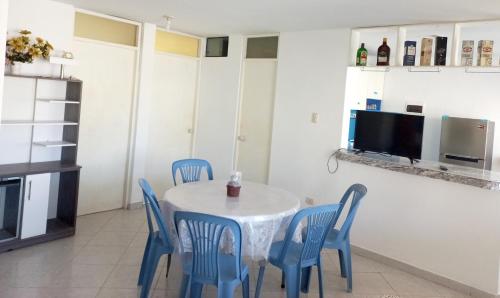 ein Esszimmer mit einem weißen Tisch und blauen Stühlen in der Unterkunft Departamento de verano - CAMANA in Camaná