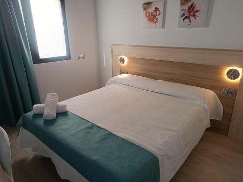 ein Schlafzimmer mit einem Bett mit einer grünen und weißen Decke in der Unterkunft Apartamentos turisticos Ávila Puerta de la Santa 2-1 in Avila