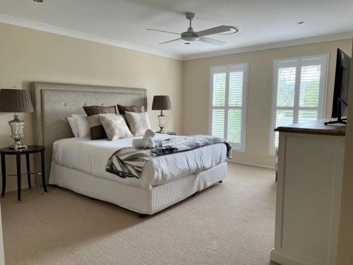 a bedroom with a bed with a teddy bear on it at HighGrove Lodge, Luxury Hunter Valley House with Views, Solar-heated Pool, Space in Millfield