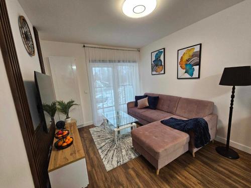 sala de estar con sofá y mesa en Apartament Rose, Osada Górska, en Szklarska Poręba