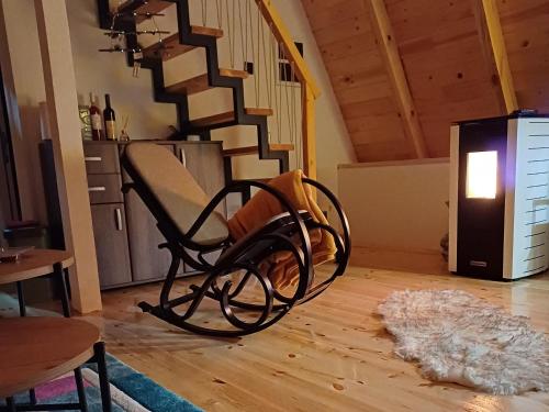a rocking chair in a living room with a staircase at Mountain house Vojinovic Planinska kuća Vojinovic in Žabljak