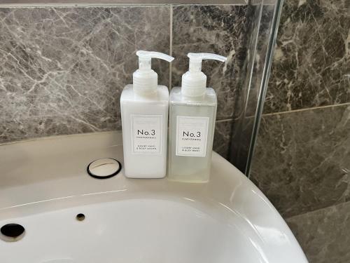 two bottles ofodorizers sitting on top of a bath tub at Remarkable 1-Bed Outhouse Studio in Dagenham in Dagenham