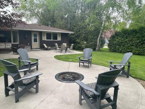 a patio with chairs and a table and a fire pit at Steps to Beach, Fantastic Sunsets, Charming 3 bedroom Cottage in Ripley