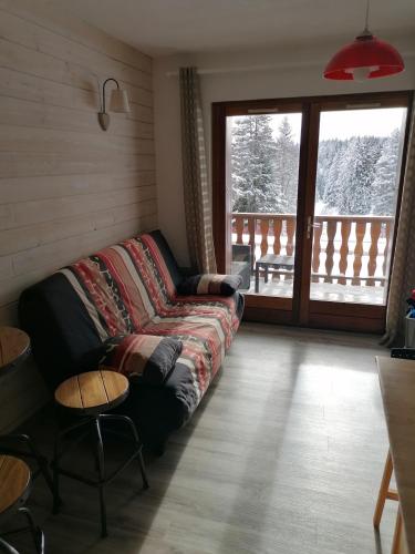 a living room with a couch and a balcony at Appartement 5 personnes en station Savoie Grand Revard in Trévignin