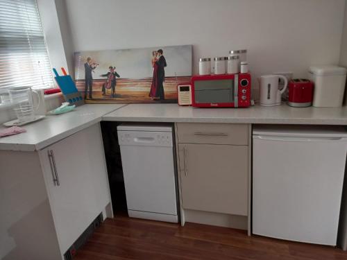 a kitchen with a counter top with a red microwave at Colchester Town, modern, detached, guest house in Colchester
