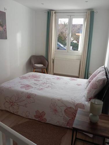 Schlafzimmer mit einem Bett und einem Fenster in der Unterkunft Appartement Cosy avec Jardin in Vaux-sur-Seine