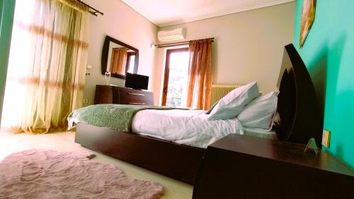 1 dormitorio con cama, escritorio y ventana en Spata sunrise house en Spáta