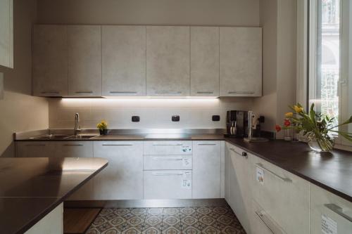 a kitchen with white cabinets and a sink at Il Giardino della Tartaruga in Genova