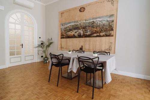 a dining room with a table and a large painting on the wall at Il Giardino della Tartaruga in Genova
