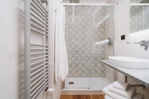 a white bathroom with a sink and a shower at Il Giardino della Tartaruga in Genova