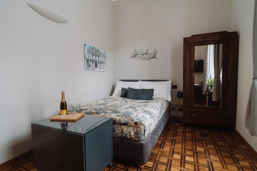 Un dormitorio con una cama y una mesa con una botella de vino en Il Giardino della Tartaruga en Génova