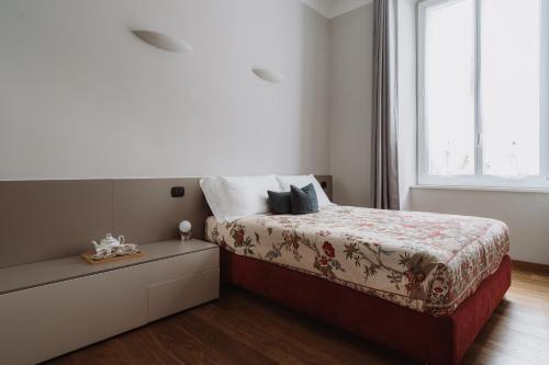 a bedroom with a bed with a dresser and a window at Il Giardino della Tartaruga in Genova