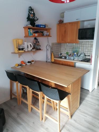 - une cuisine avec une table en bois et des chaises dans l'établissement Appartement 5 personnes en station Savoie Grand Revard, à Trévignin