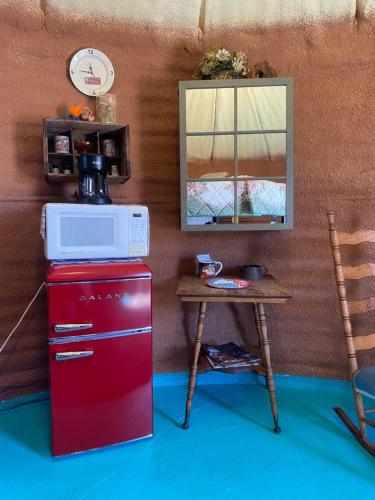 a red refrigerator next to a table with a microwave at JMA Granary in Riverton