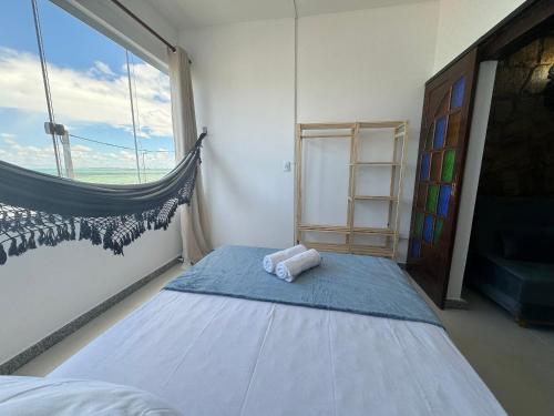 a bedroom with a bed and a large window at Paraiso Tropical a beira mar - WIFI 200MB - TV Smart - Cozinha equipada - Portaria 24h in Rio das Ostras