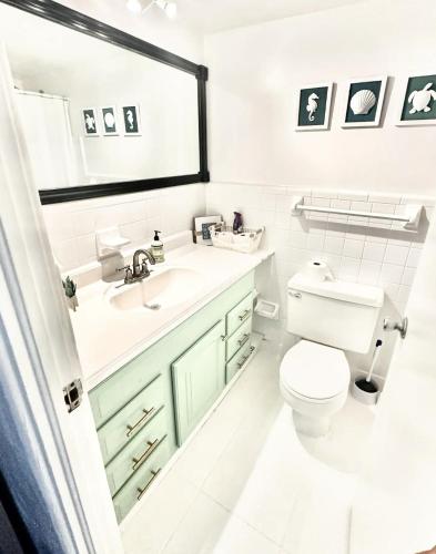 a white bathroom with a sink and a toilet at OCEAN VIEW Condo Daytona Beach in Daytona Beach