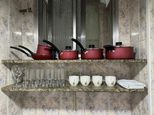 リオ・ダス・オストラスにあるApto Paradisíaco Beira Mar | ROMM108の鍋、フライパン、ワイングラス入り棚