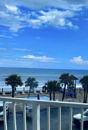 een uitzicht op een strand met palmbomen en de oceaan bij OCEAN VIEW Condo Daytona Beach in Daytona Beach