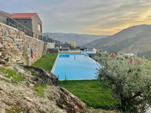 a large swimming pool sitting next to a building at Quinta do Casal Bystol, Casa 1 in Casal de Loivos