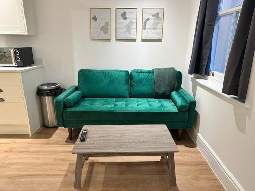 a green couch in a living room with a coffee table at 2 Bedroom Luxury Apartment by the Sea in Kent