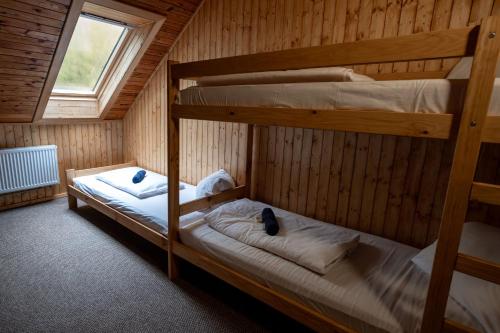 two bunk beds in a room with a window at Penzion a Restaurace Kamínek in Doksy