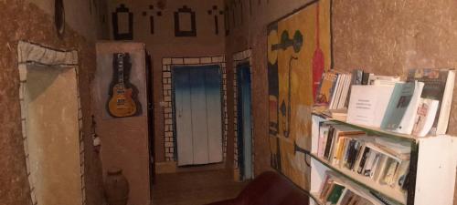 un couloir avec une porte et une guitare sur le mur dans l'établissement Oasis travel, à Tazouka
