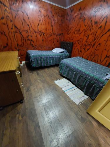 a room with two beds and a wooden floor at Noface 11 in Los Vilos