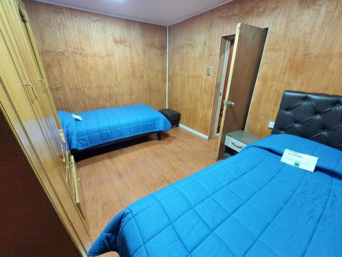 a small bedroom with a blue bed and a mirror at Noface 11 in Los Vilos
